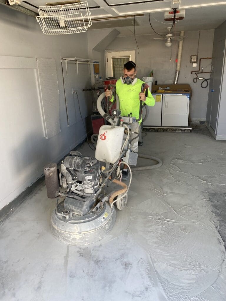 A man in yellow shirt standing next to a machine.