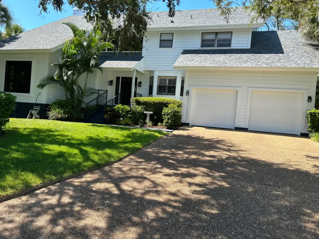 A large white house with two garage doors.